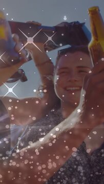 Vertical video: Woman holding rollbar bringing beer up, adding sparkles as group toasting marketing