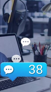 Vertical video: Chat bubble popping at office, sending icons over laptop by user, count reaching 95