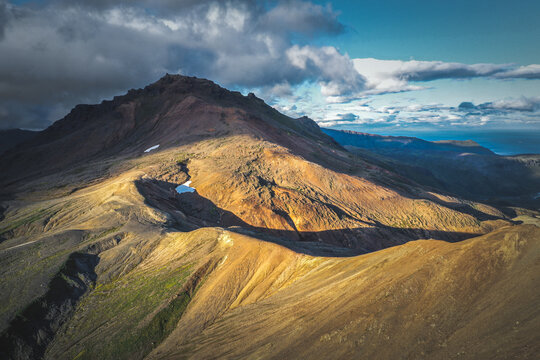 Aerial view of Okmok Volcano caldera with crater lake and glacial snow, Umnak Island, Alaska