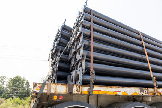 Heavy steel pipe load on truck for industrial construction transport showing strong reliable logistic cargo moving large material across outdoor highway landscape