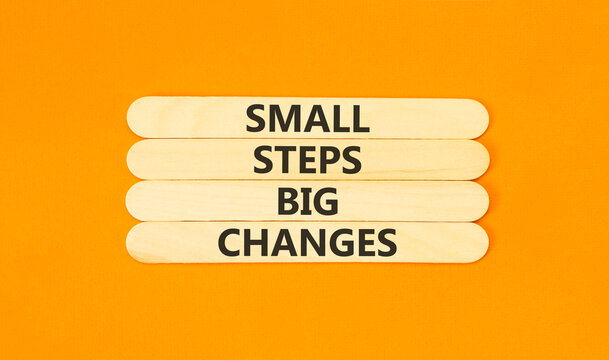 Small steps big changes words symbol. Concept words Small steps big changes on beautiful wooden sticks. Beautiful orange background. Business motivational small steps big changes concept. Copy space.