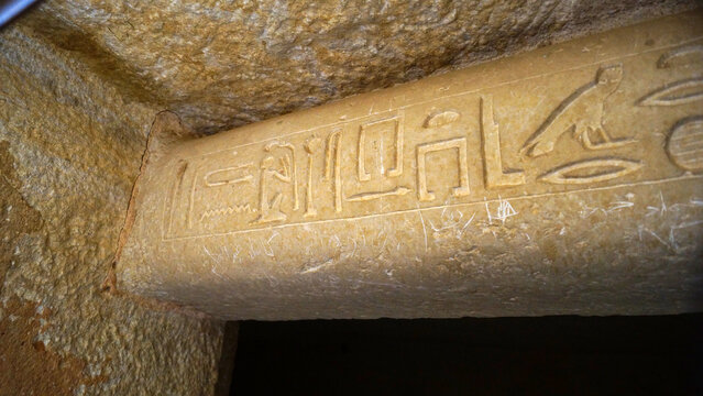 Сlose-up view of the beginning of a limestone architrave featuring ancient Egyptian hieroglyphs. Located in the Eastern Cemetery of the Giza Plateau, near the three Pyramids of the Queens