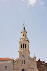 Fototapeta premium Tall stone bell tower with a clock