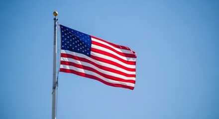 Fototapeta premium American flag waving proudly against a bright blue sky