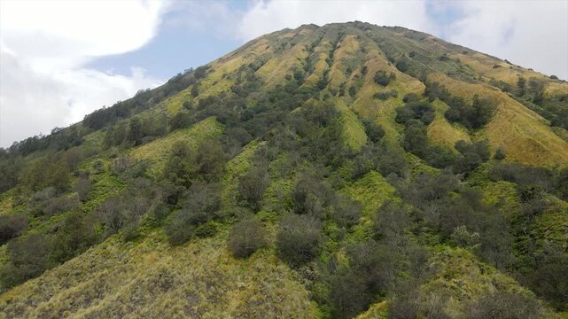 4K aerial view of the iconic Mount Batok with its lush green ridges and volcanic caldera floor.