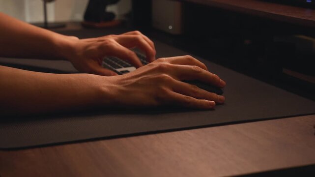 Person's hands using computer mouse and keyboard
