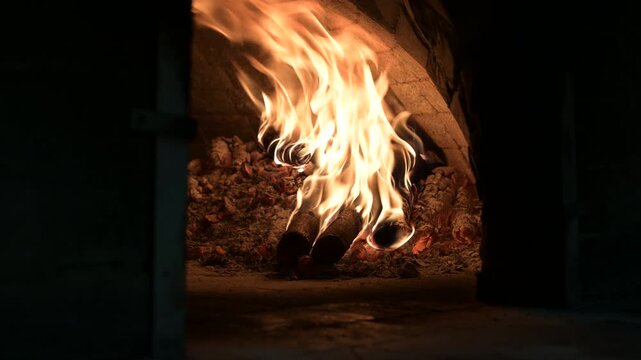 Fuoco arde in un forno a legno di una pizzeria