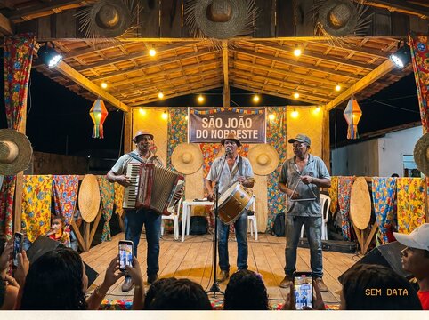 A trio of accordion players performing on a stage during a festa junina celebrating S&atilde;o J&otilde;ao