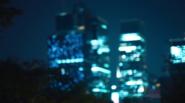 Abstract blurred city skyline with bokeh lights at night, Defocused urban skyscrapers with glowing blue lights and dreamy atmosphere 4k