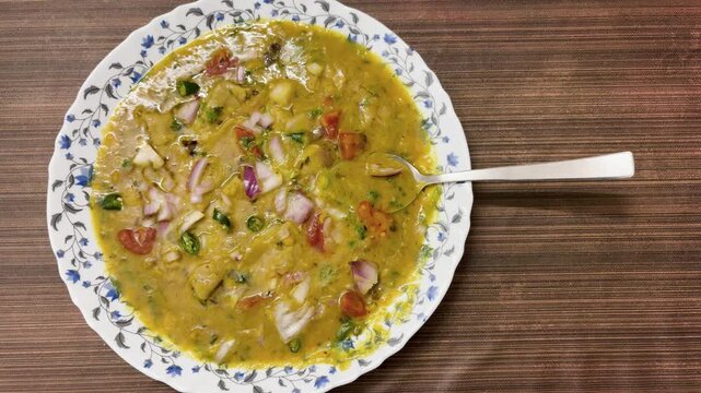 indian Dal Pitha curry with chopped onions and tomatoes served in plate