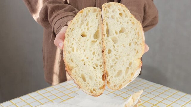 person is holding white bread in hands. homemade sourdough bread with crispy crust. Bakery products. yeast-free sourdough bread. healthy and healthy food. bakery. health care, gluten-free farm flour.