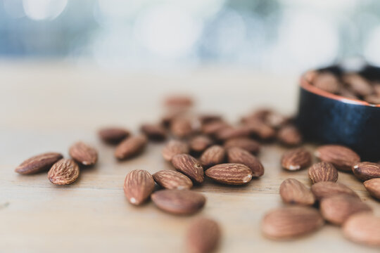 Whole organic almond nuts on wood table