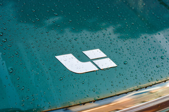 Minsk, Belarus. Aug 27, 2025. Li Xiang wet front emblem on green electric car hood, modern chinese automotive branding, innovative electric vehicle design. LI badge covered in rain drops close-up.