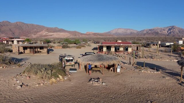 Sunrise shows the landscape of Bahia De Los Angeles in Baja California. People prepare for a day of camping and beach activities.