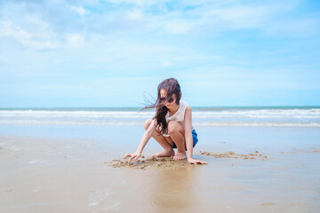 Fototapeta premium Child playing with sand near ocean at beach during summer vacation capturing playful family lifestyle moment with freedom happiness and outdoor activity