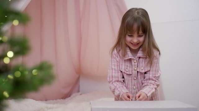 Excited young girl opening a gift box and finding a cute, fluffy rabbit as a christmas present