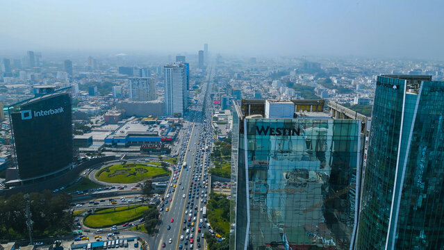 Comprehensive aerial view of the bustling Javier Prado avenue traffic and the iconic glass facade of the Westin Hotel in the financial district.