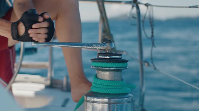 Woman sailor works with rope on a sailing boat. Couple sailing in the tropical calm sea during nice sunny day