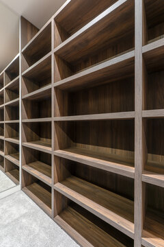 Modern walk in closet with custom wooden shelving system empty wardrobe storage with built in shelves and mirror contemporary interior design luxury dressing room