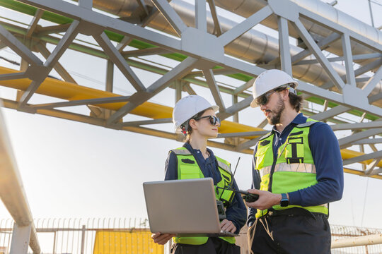 Petroleum engineers with hardhat working at oil refinery site