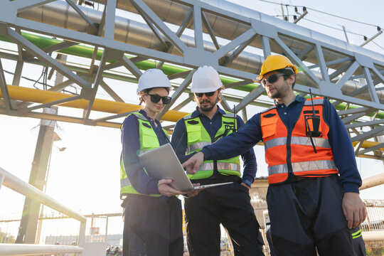 Petroleum engineers with hardhat working at oil refinery site