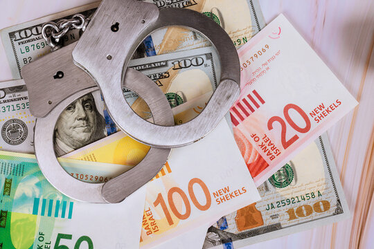 Handcuffs on US dollars Israeli new shekels at law event.