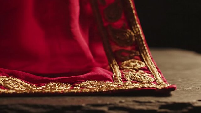 Close up of luxurious red fabric with intricate gold embroidery detail, textile texture, rich cultural heritage, opulent design