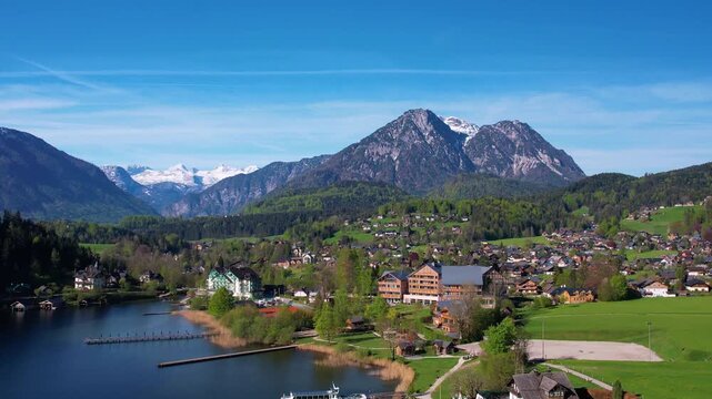 Explore the serene beauty of Altausseer See in Austria Salzkammergut with a luxury village near the tranquil lake. The stunning mountains reflect in the calm water, capturing a peaceful lakeside scene