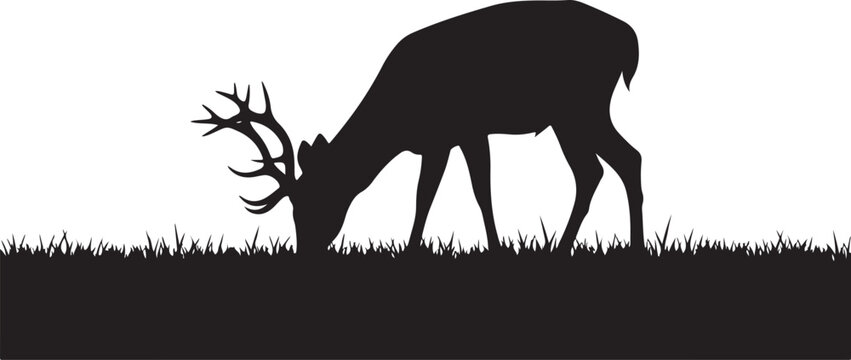 Black silhouette of deer with antlers grazing on grass