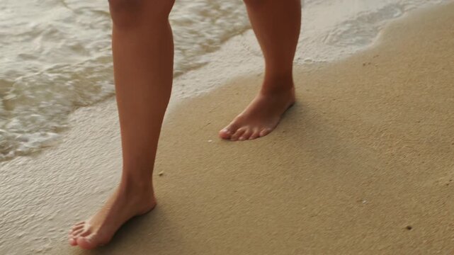 Bare feet hopping across wet sand, playful morning energy with small splashes and quick steps, seaside workout and dancelike movement, sunlit highlights on skin, footprints and sandbar patterns