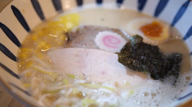Cinematic close-up of authentic Hokkaido miso butter corn ramen topped with chashu pork, melting butter, and narutomaki, appetizing Japanese food concept