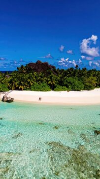 Pristine tropical island with white sand beach, lush green trees, and crystal clear ocean