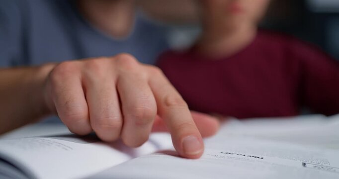 Parent Helping Son With Exercises. Caring Father Directs Son In Solving Workbook Questions Closely