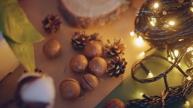 Fairy lights around rustic present setup, scattered nuts, pinecones, cotton and twine creating warm glow and handcrafted wrapping scene golden bokeh, textured kraft paper, intimate craft mood