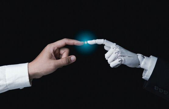 Human finger touching robotic finger with glowing light for AI connection concept
