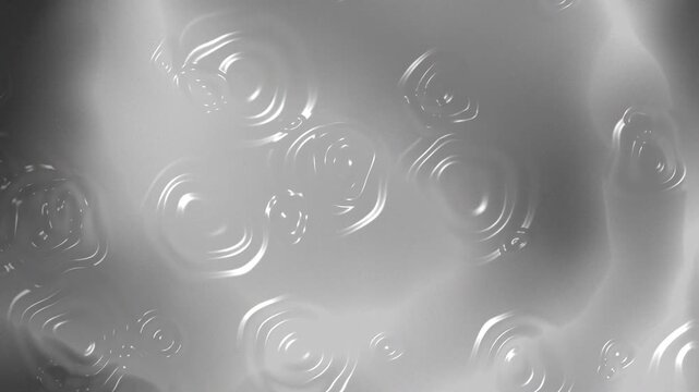 A monochrome abstract liquid surface with soft ripples and circular wave patterns. The smooth gradients and reflective texture create a calm, modern visual with depth and fluid motion