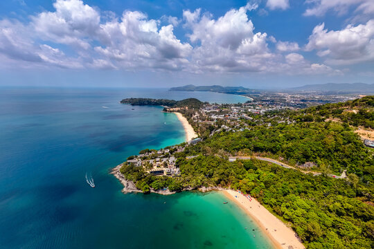 Aerial view of Haad Laem Sing Beach Phuket Thailand. Rest in clear turquoise water while people relax on the sandy shore backed by tropical jungle