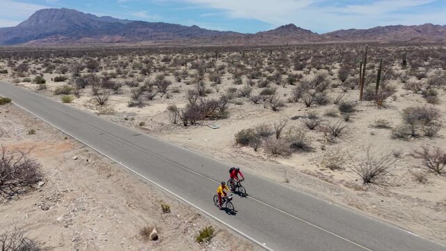 Watch a man and woman bike near La Gringa in Baja California, Mexico, by the Sea of Cortez in the desert landscape.