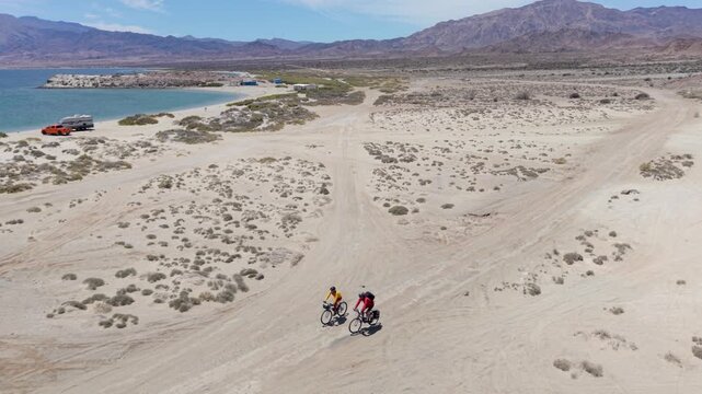 A mature man and woman bike in Baja California Mexico near La Gringa along the beautiful Bahia De Los Angeles by the Sea of Cortez.