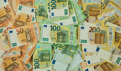 Obraz premium Euro banknotes are arranged in grouped stacks by denomination on a wooden surface. Cash savings and wealth concept for finance, budgeting, investment and banking use.