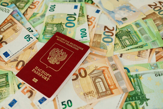 Russian passport on euro banknotes background symbolizes emigration, relocation and travel planning. Immigration concept with documents, European money and vacation budget.