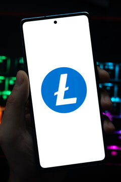 Punta Arenas, Chile &ndash; May 04, 2026: Close-up of a mobile device screen showing the Litecoin digital currency symbol, held by a user in a dimly lit room with vibrant RGB keyboard lighting