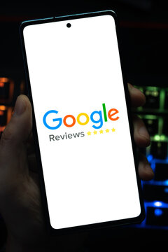 Punta Arenas, Chile &ndash; May 04, 2026: Close-up of a mobile device screen showing the Google Reviews branding and rating system, held by a user in a dimly lit room with vibrant RGB keyboard lighting