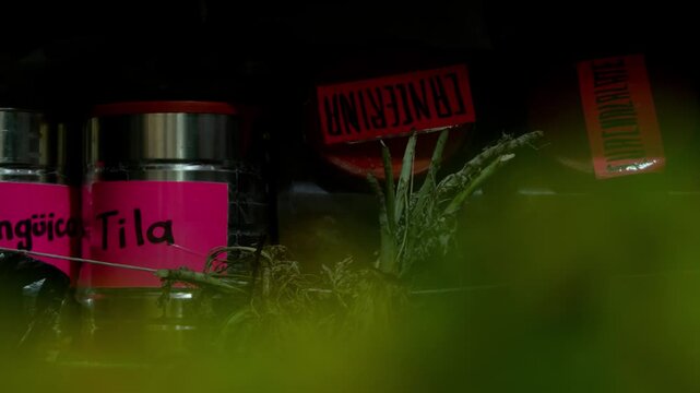 Frascos de hierbas medicinales tradicionales con etiquetas hechas a mano en mercado local - 4K