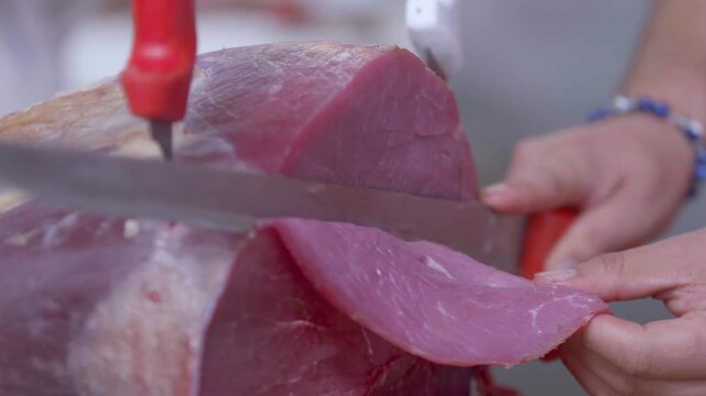 Primer plano de manos de carnicero cortando bistec de res fresco en mercado tradicional - 4K