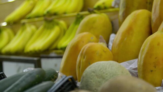 Pl&aacute;tanos y papayas frescos exhibidos en estante de mercado tradicional - 4K