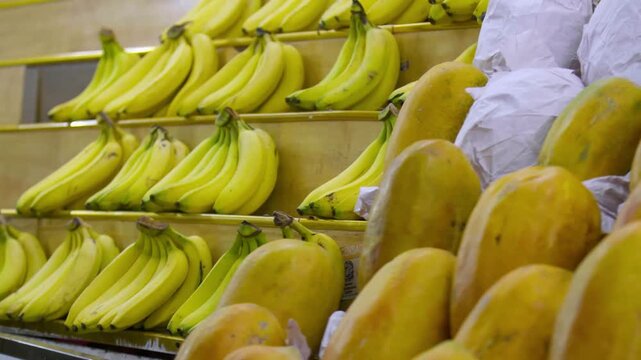 Pl&aacute;tanos y papayas frescos exhibidos en estante de mercado tradicional - 4K