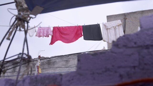 Ropa tendida sec&aacute;ndose en azotea de barrio popular 4k