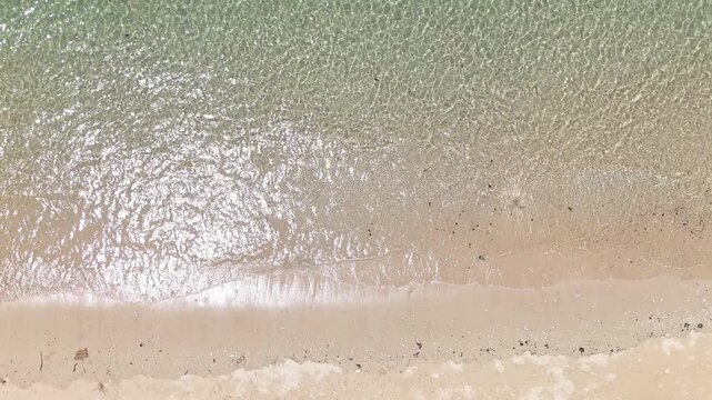 Aerial View of Serene Sandy Beach with Gentle Waves Lapping Shoreline Creating Peaceful and Calming Ocean Atmosphere