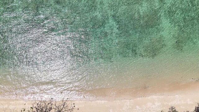 Aerial View of Serene Beach Tranquil Shoreline with Turquoise Ocean, Gentle Waves, and Inviting Sand for Relaxing Escape